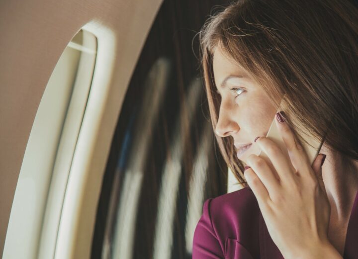 beautiful young woman sits in a plane near the window